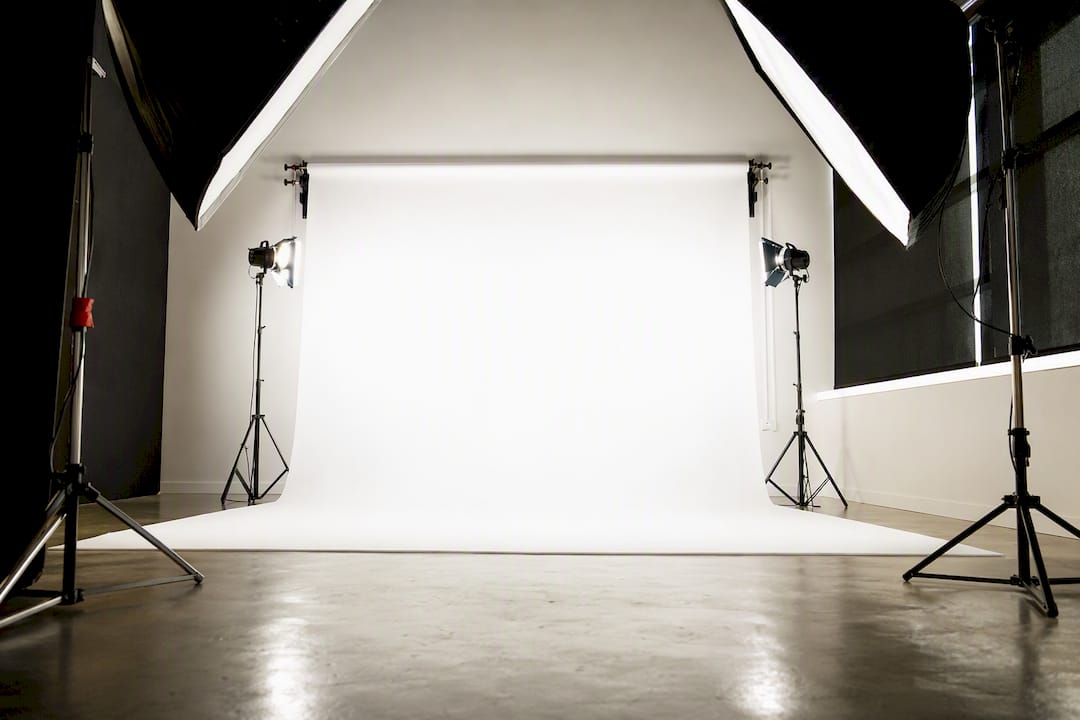 Studio lights illuminating a white headshot backdrop