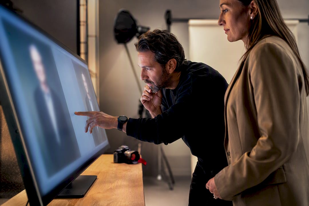 Executive reviewing headshot on large monitor